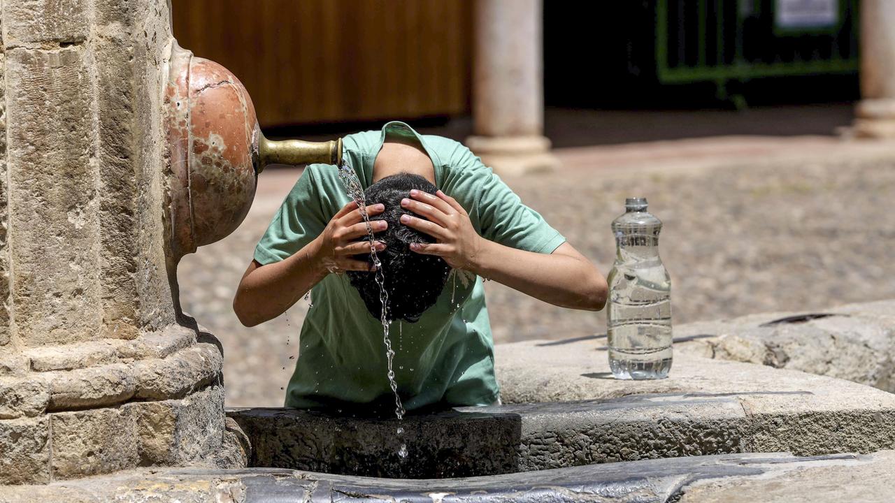 A tourist cools off at a fountain in Cordoba, Spain