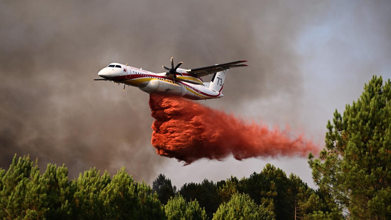 A plane releases fire retardant over a forest near Blagon, France