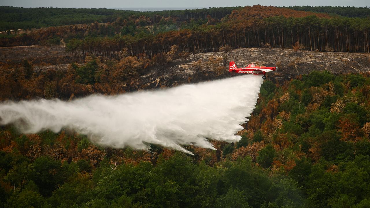 A plane drops water during a wildfire in Le Porge, France