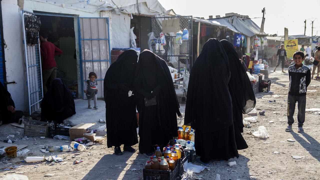 four women in full Islamic dress in marketplace