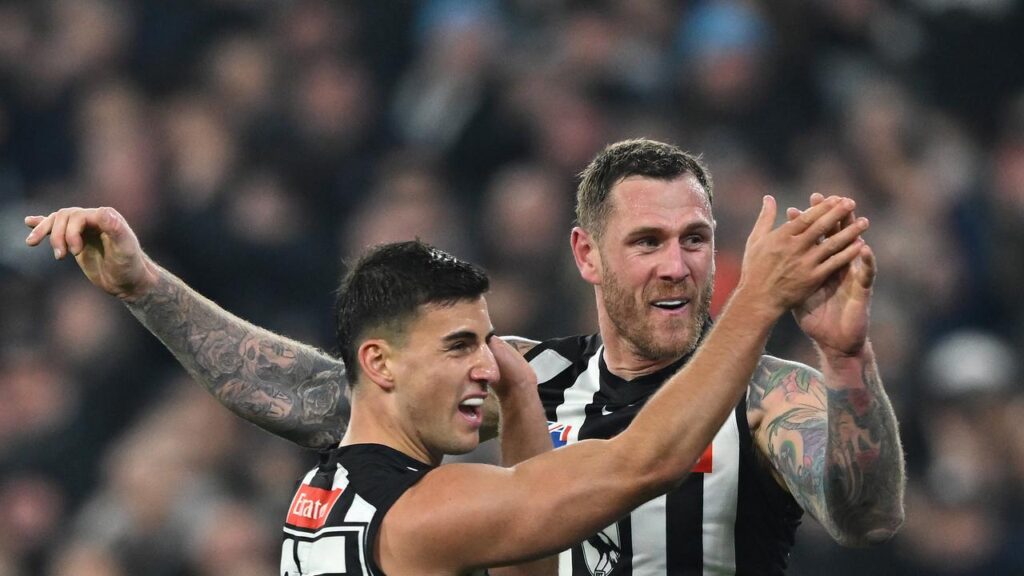 Tim Membrey celebrates with Collingwood teammate Nick Daicos after kicking a goal.
