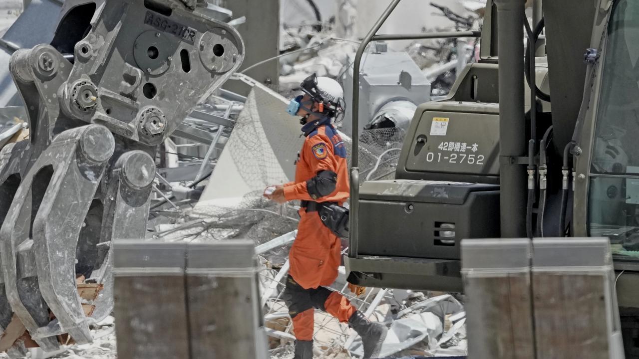 A firefighter searches the damaged AEON Mall in Japan