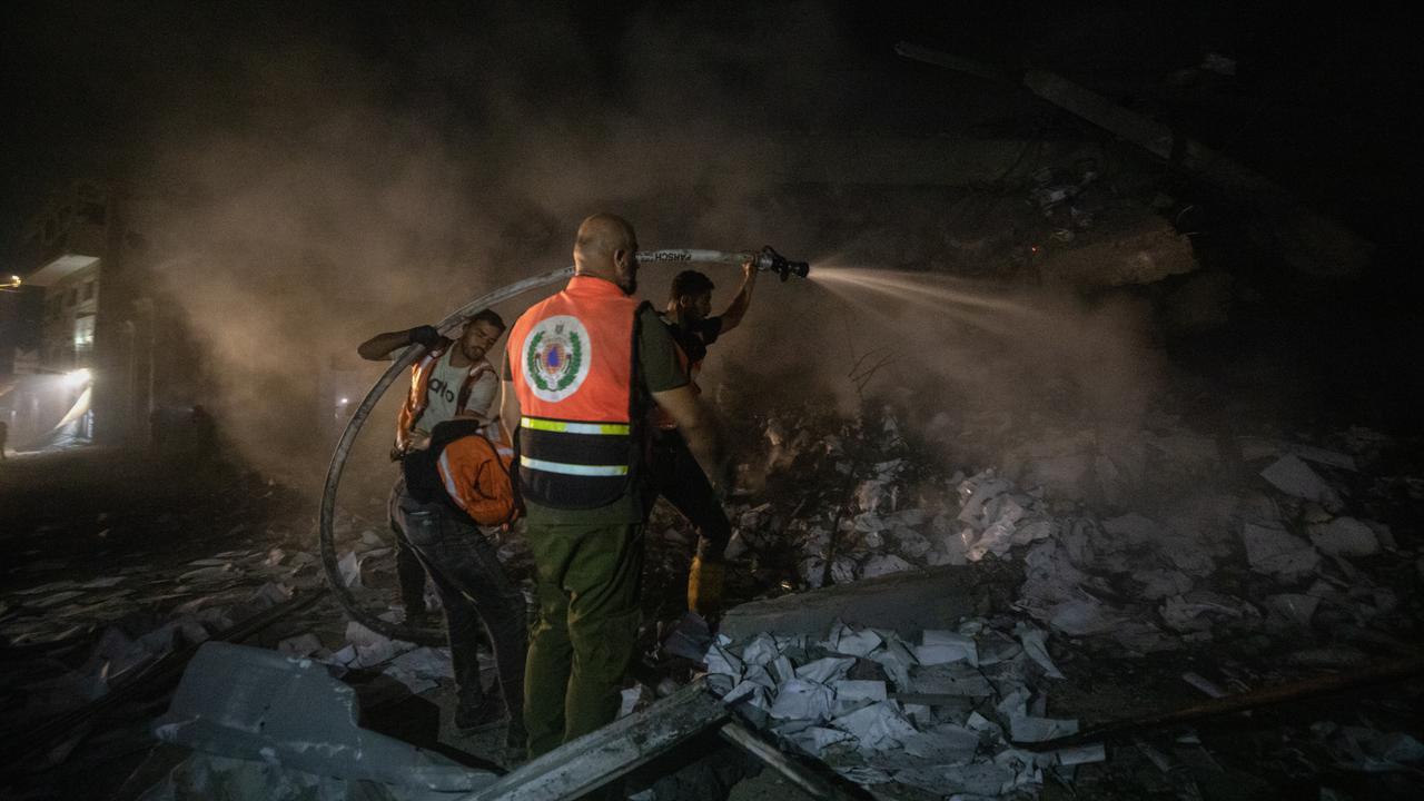 Firefighters try to extinguish a fire after an Israeli attack