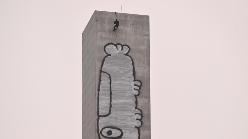 A vandal has caused traffic chaos after scaling a 140-metre pillar on a major city bridge.
