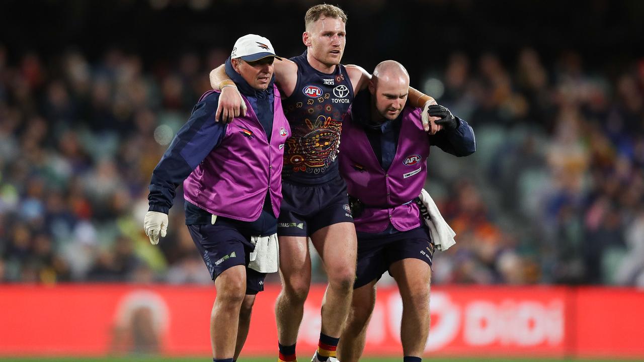 Rory Laird of the Crows leaves the field injured
