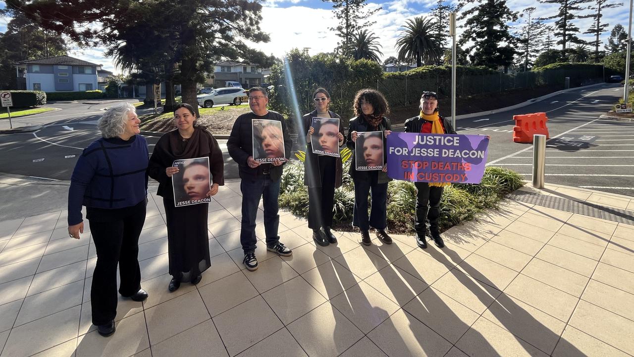 several people holding portraits of Jesse Deacon stand outside court