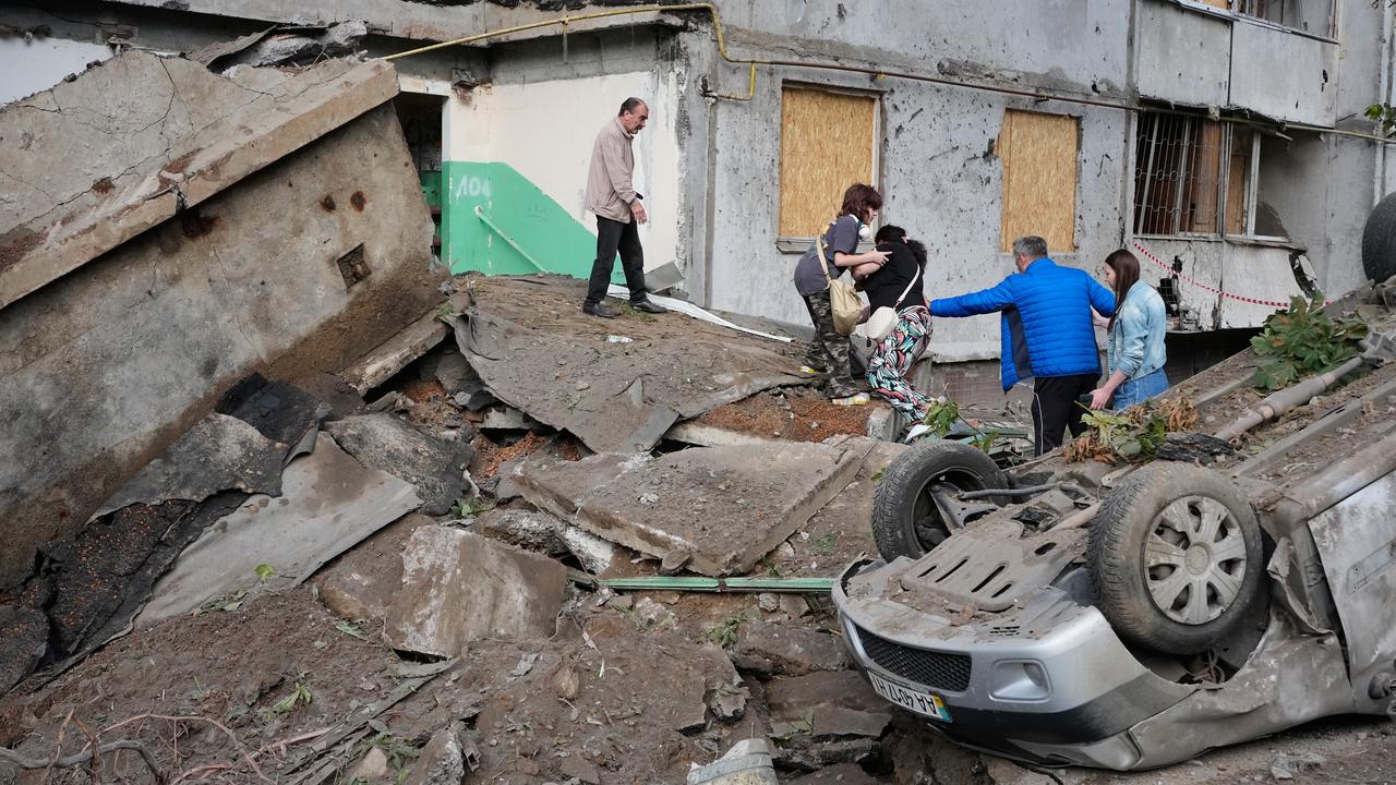Kyiv residents walk amid debris following a Russian attack