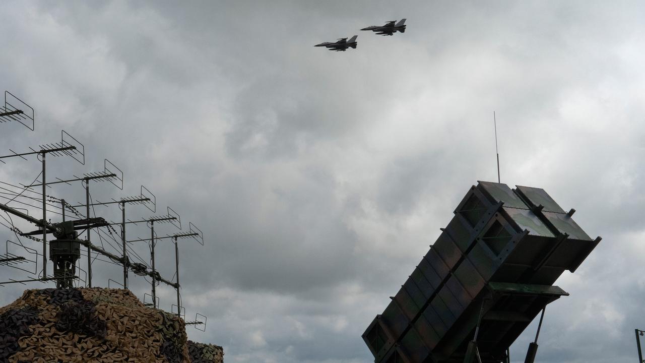 Ukrainian Air Force's F-16 jets fly over a Patriot defence system