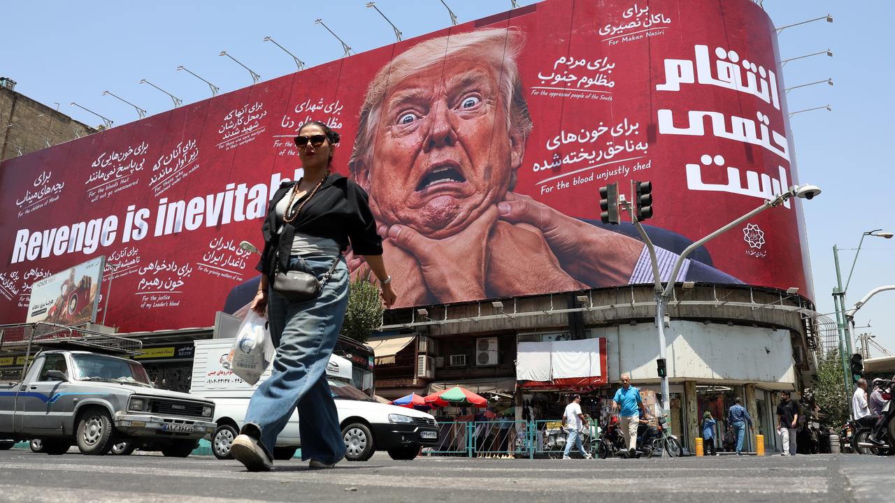 A woman walks past an anti-US billboard in Tehran, Iran
