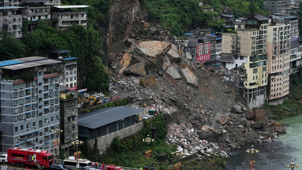 Rescuers stand along a bridge a landslide in China's Chongqing