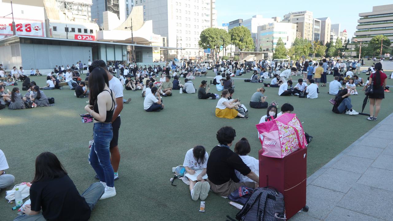 People gather outside following a powerful earthquake in Kumamoto City