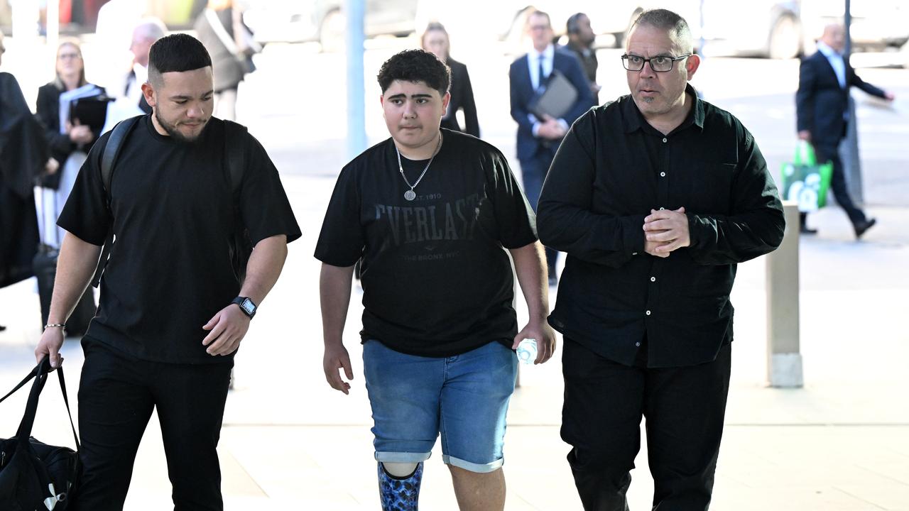 teenage boy walks to court alongside father