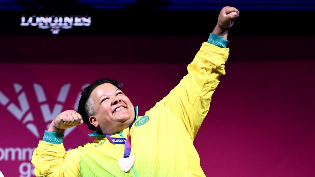 Hani Watson beams in joy at her medal ceremony after earning para powerlifting bronze in Glasgow.

