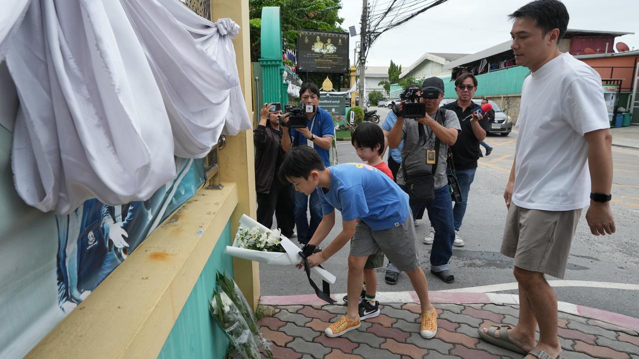 People lay flowers at the gate of Debsirin Nonthaburi School