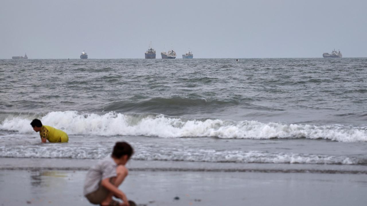 Children play as vessels are anchored in the Strait of Hormuz