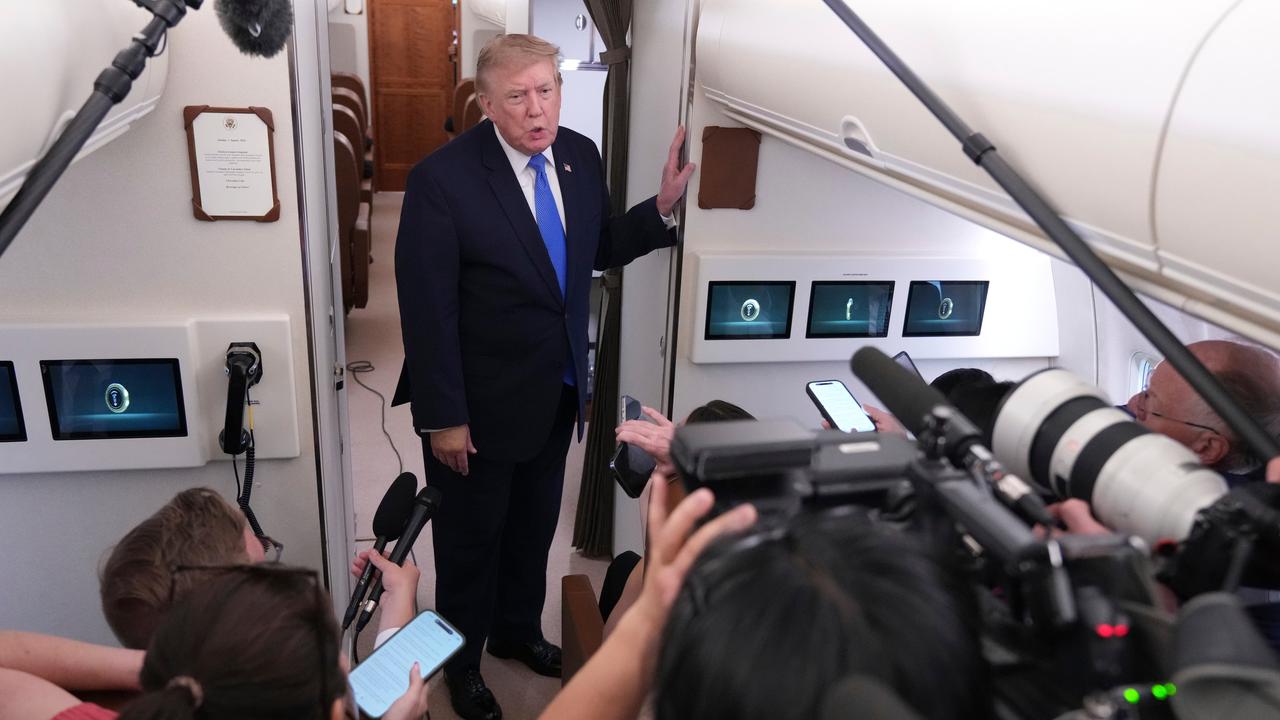 President Donald Trump speaks to reporters onboard Air Force One