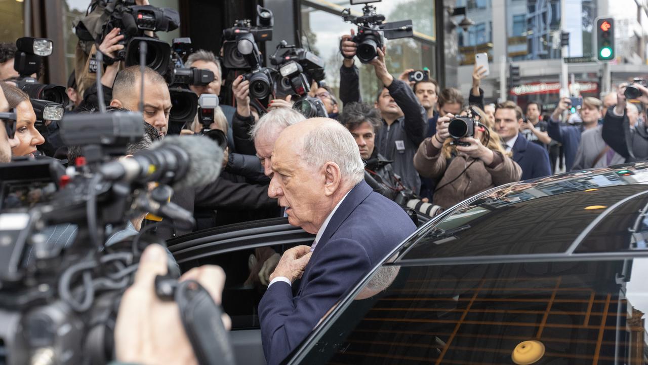 Alan Jones exits car to throng of media