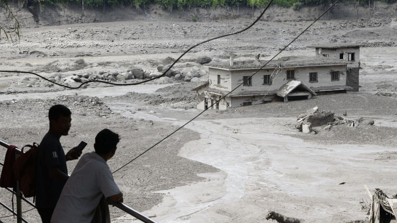 People watch floodwaters sweeping through Trishuli Bazar in Nepal