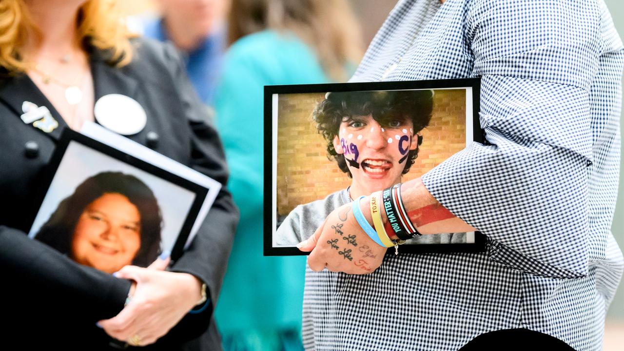 Mothers hold a picture of their dead children