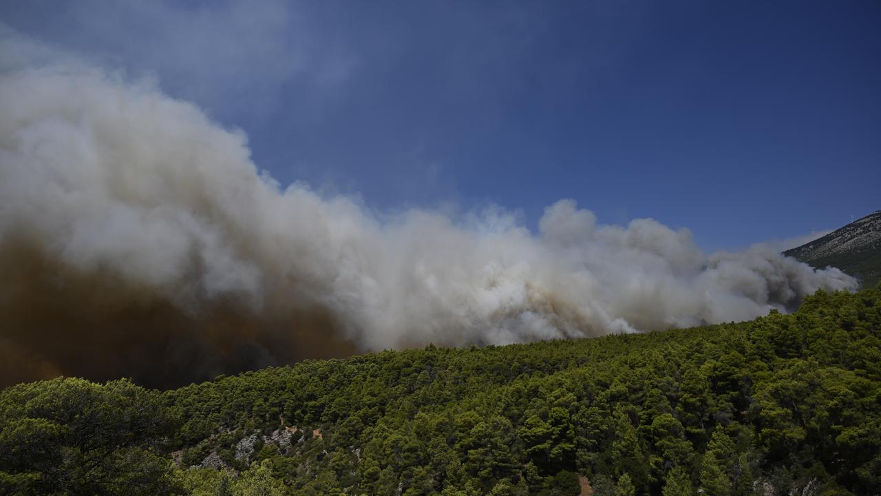 Smoke rises into the sky from a wildfire near Porto Germeno, Greece
