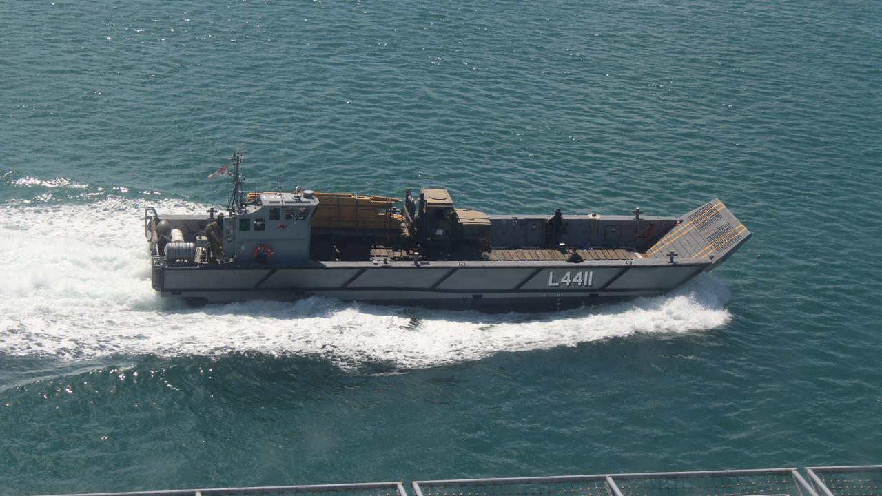 A landing craft passes HMAS Canberra.