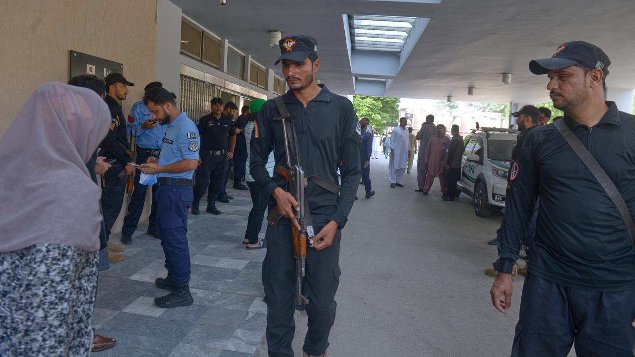 Police stand guard outside a nursery following a fire in Islamabad