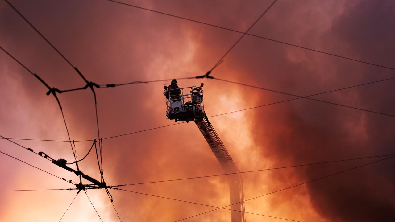 Firefighters try to put out a fire at a city book market
