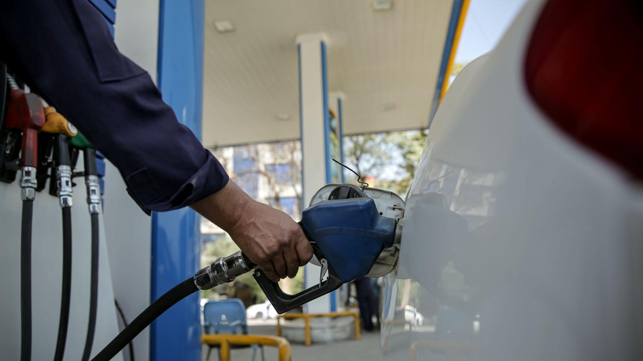 A person refuels at a petrol station