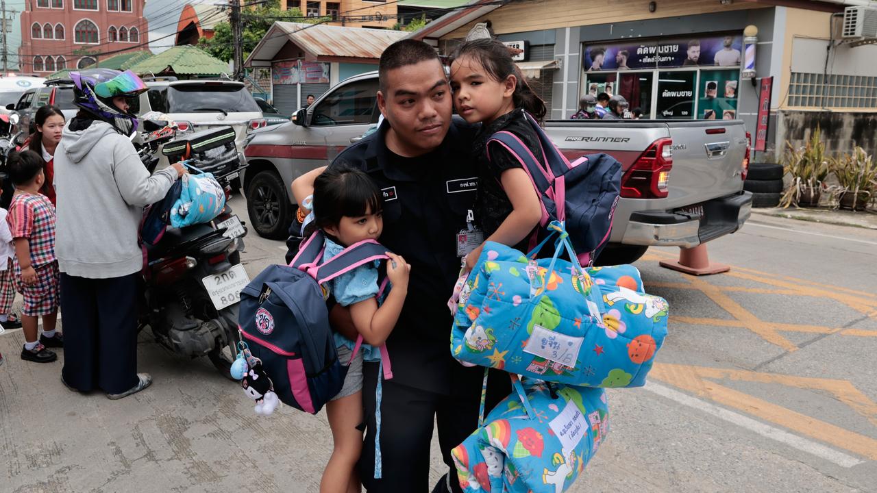 A man carries schoolgirls after a school shooting in Thailand