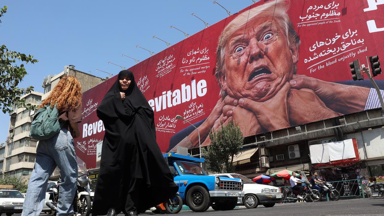 Iranians walk near an anti-Trump billboard in Tehran, Iran