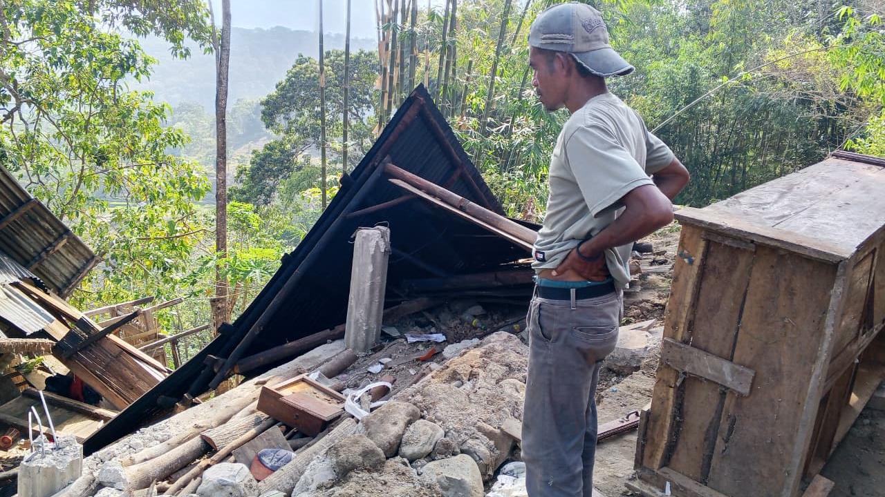A man looks at damage after an earthquake in East Manggarai, Indonesia