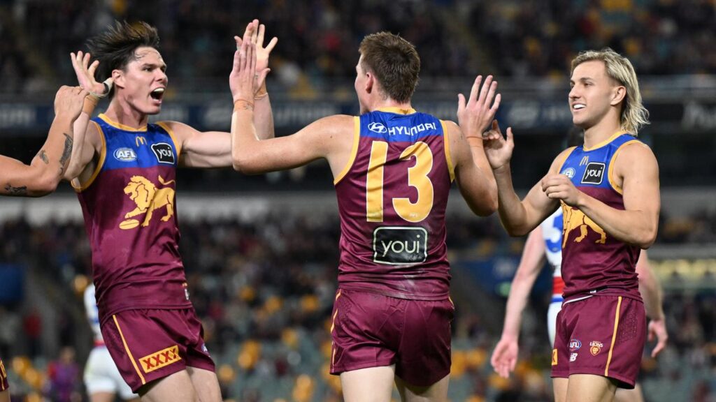 Logan Morris (C) of the Lions celebrates kicking a goal with Eric Hipwood (L) and Kai Lohmann.
