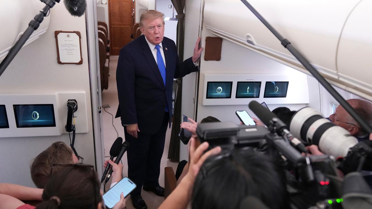 President Donald Trump speaks to reporters onboard Air Force One