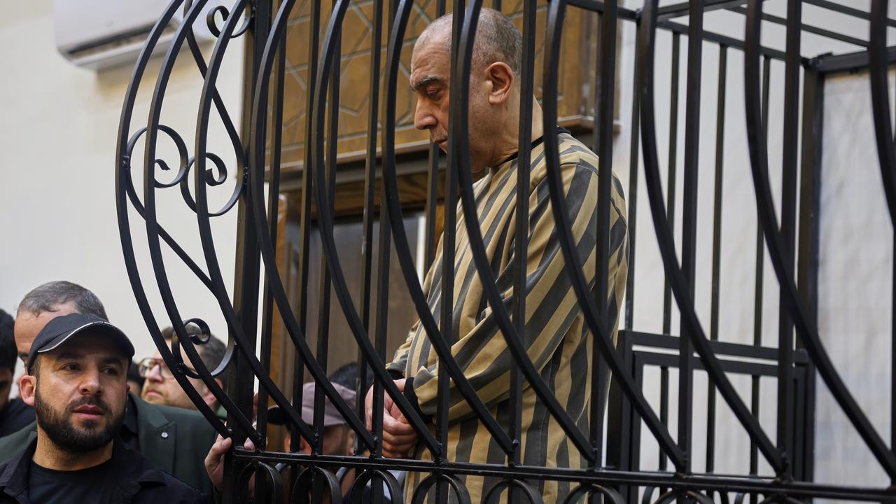 Atef Najib in the defendant's cage in Damascus, Syria