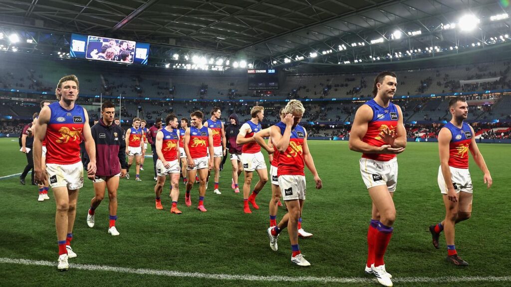 Disconsolate Brisbane Lions players trudge off after their shock AFL hammering by Carlton.
