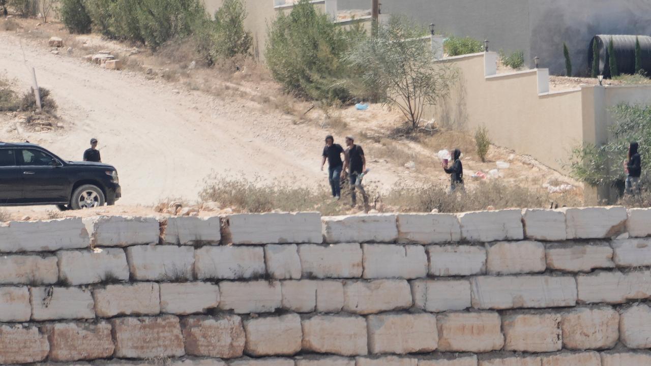 Israeli settlers gather in front of homes in Qusra