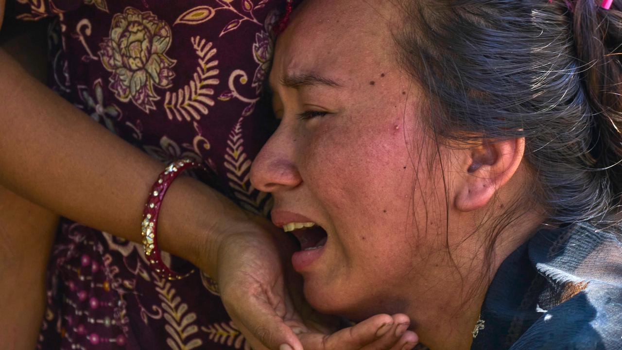 A girl cries as she waits for news of relatives missing after floods