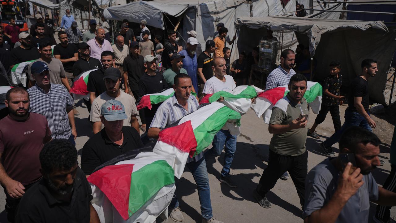 Mourners carry recently recovered remains of Palestinians in Gaza