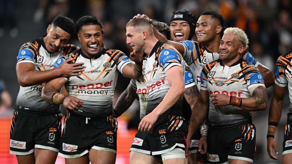 Man of the moment Adam Doueihi’s teammates got around him following his try for Wests Tigers.   
