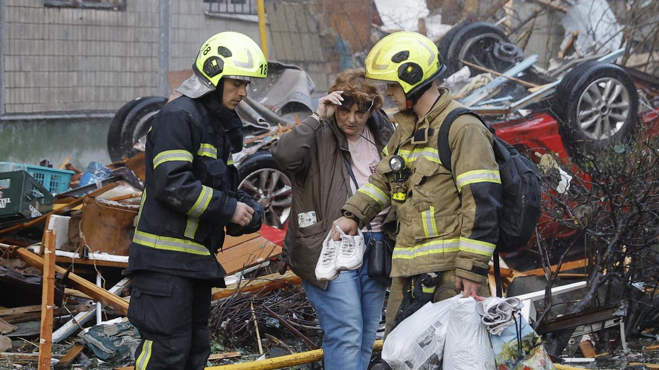 Rescuers help a woman after a Russian missile strike in Kyiv, Ukraine