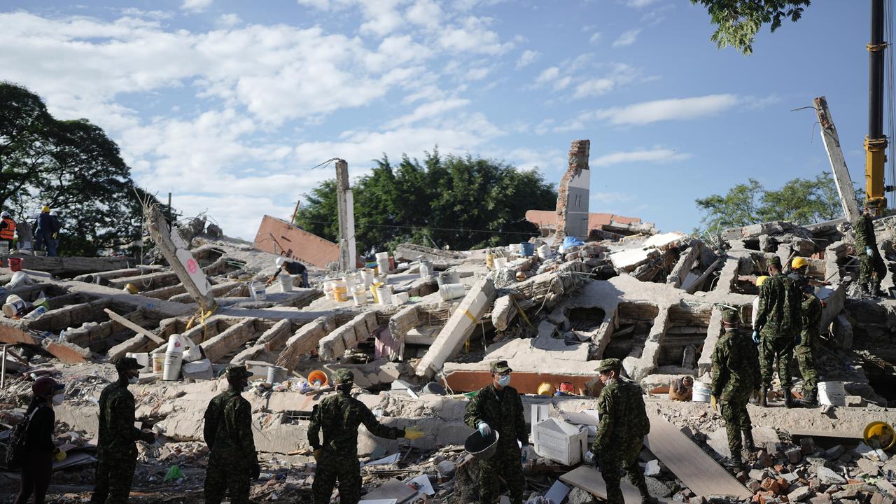 Soldiers clear debris three days after an earthquake