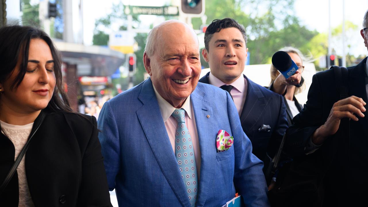 Alan Jones smiling while leaving court