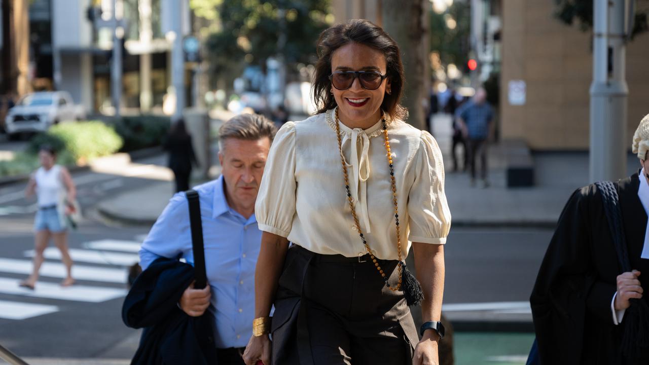 Amanda Ghost smiles while walking to court