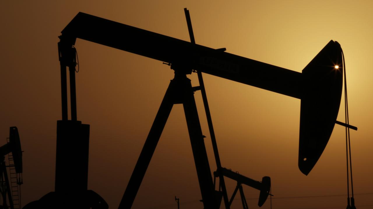 oil pumps work at sunset in the desert oil fields of Sakhir, Bahrain