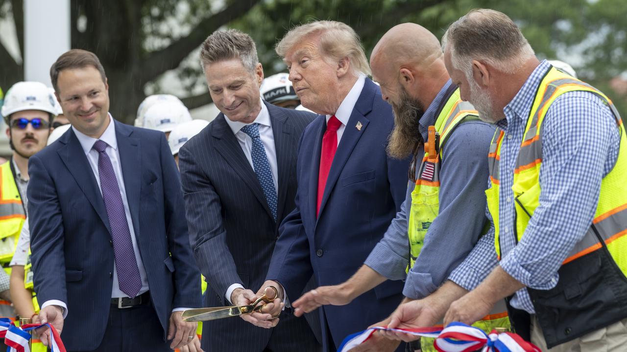 Donald Trump cuts a ribbon for a new helipad at the White House