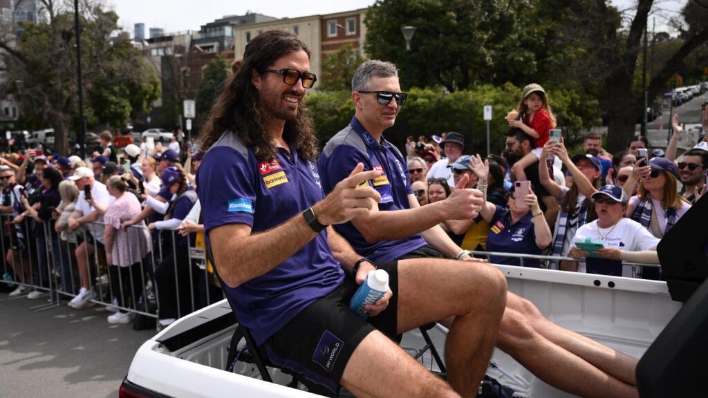 Justin Longmuir gives the thumbs-up alongside his captain Alex Pearce in the AFL grand final parade.
