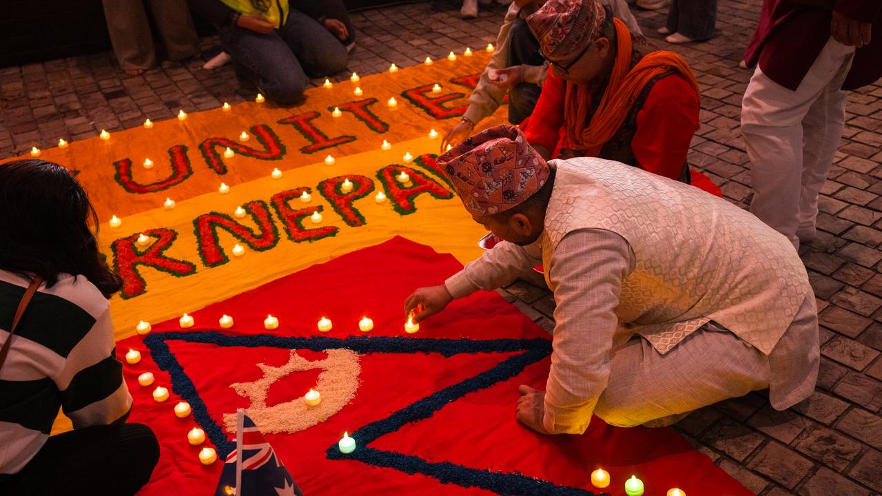 Members of the Nepalese community create a candlelit vigil