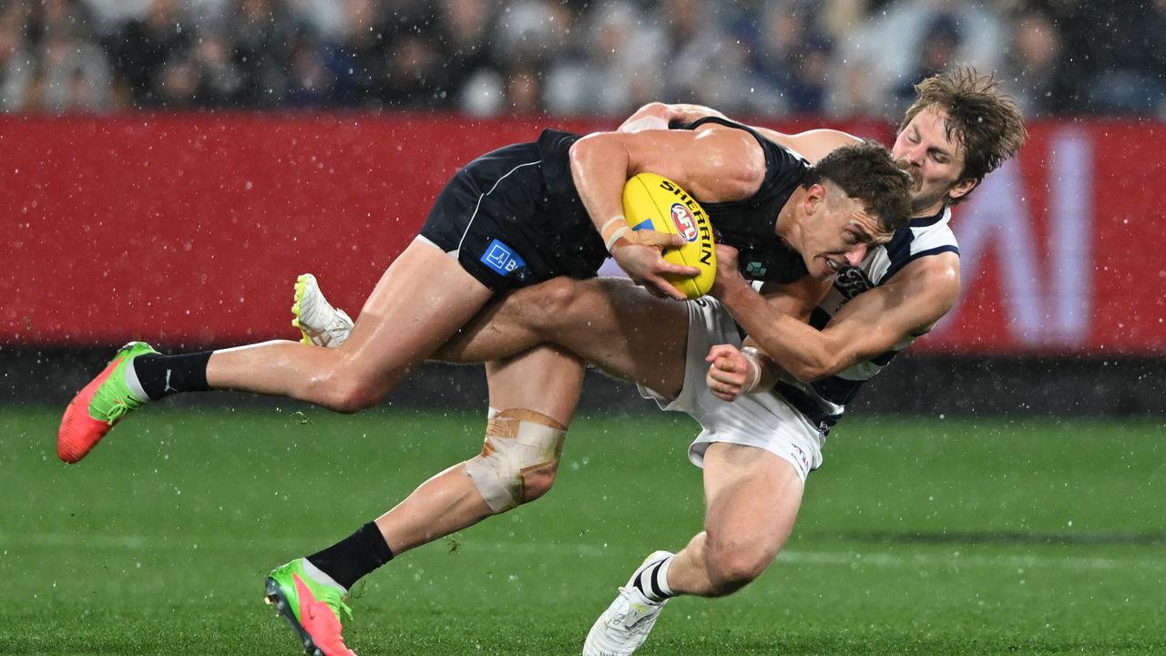 Geelong's Tom Atkins stopped Carlton captain Patrick Cripps.