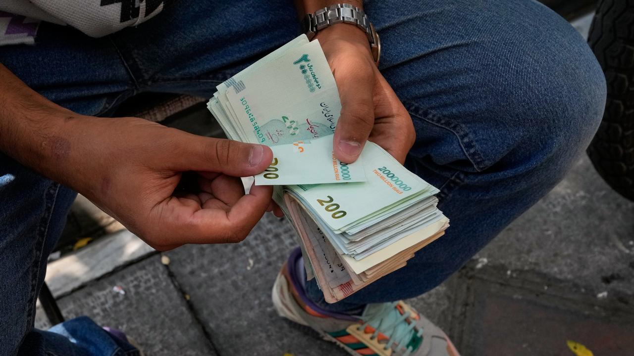 A money exchanger counts Iranian banknotes in Tehran