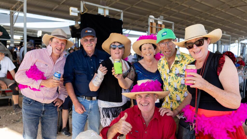 A cheerful group of racetrack patrons live it up in Birdsville after travelling from Dubbo in NSW.
